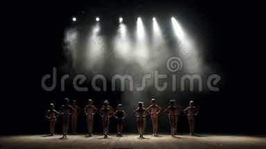 一群小孩子舞者在黑暗中<strong>上台</strong>表演，他们确实鞠躬。 芭蕾舞